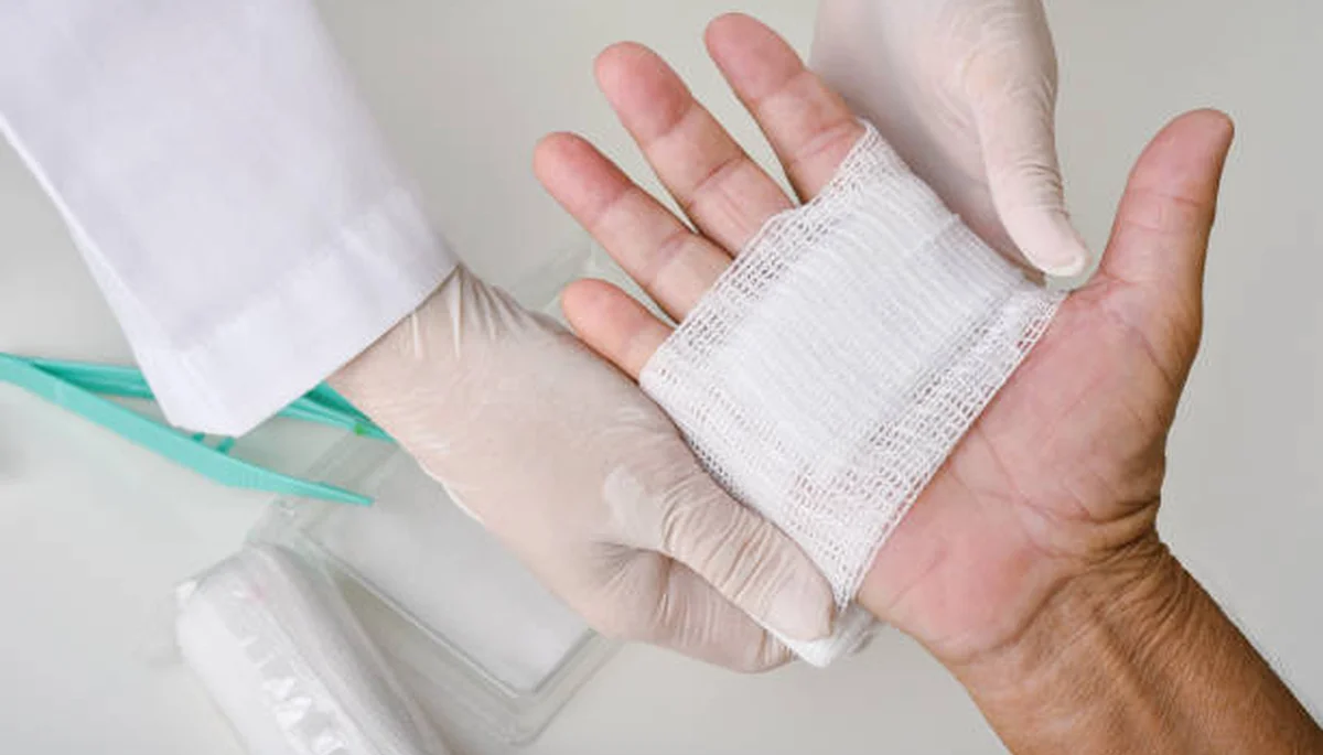 Medical professional examining and treating a wound on a patient's arm